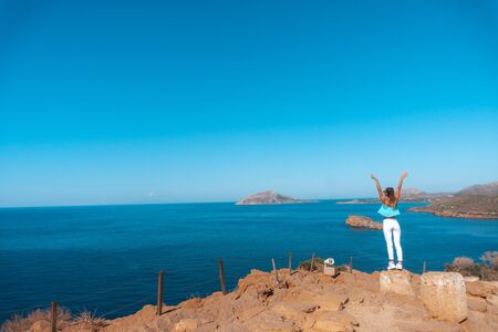 young girl on a high cliff above the sea