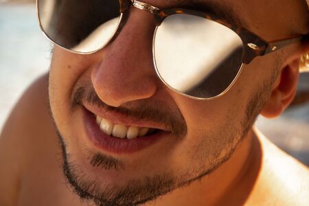 close up portrait of a happy man in sunglasses looking at the cameraの写真素材