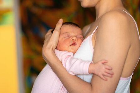 cutie little baby girl sleeps in mother handsの写真素材