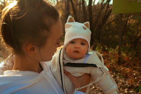 beautiful young mom with baby girl in autumn