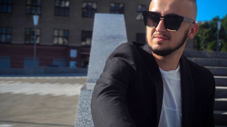 glamour young business man in black sunglasses looking away