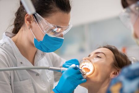 dentist and assistant treat the teeth of a cutie patient