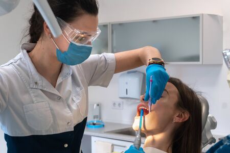 portrait of dentist treats teeth to a girl in a clinicの写真素材