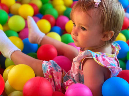 portrait of pretty little baby girl having fun in the ball poolの写真素材