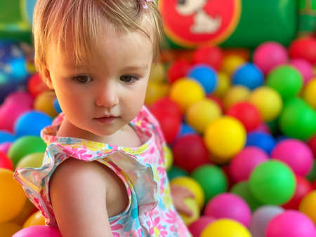 portrait of cute little baby girl having fun in the ball poolの写真素材