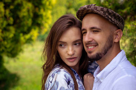 portrait of beautiful couple in love both looking away and smiles outsideの写真素材