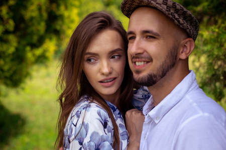 horizontal portrait of beautiful couple in love both looking away and smiles outsideの写真素材