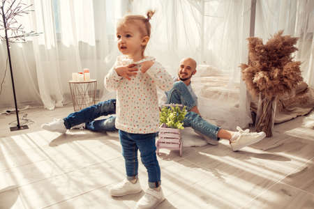 Young family at home in ltgh bedroom with thier daughter. Family time at homeの写真素材