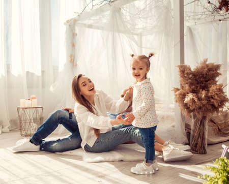 Young family at home in ltgh bedroom with thier daughter. Family time at homeの写真素材