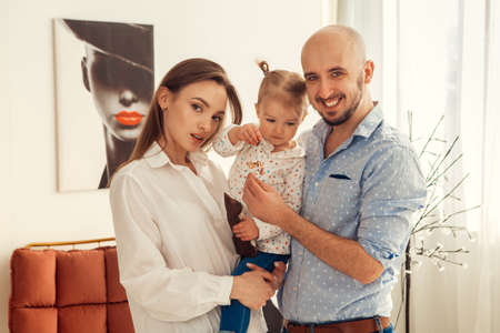 Mother father and little daughter posing on camera at home. Family timeの写真素材