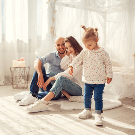 Young family at home in ltgh bedroom with thier daughter. Family time at homeの写真素材