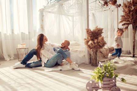 Young family at home in ltgh bedroom with thier daughter. Family time at homeの写真素材