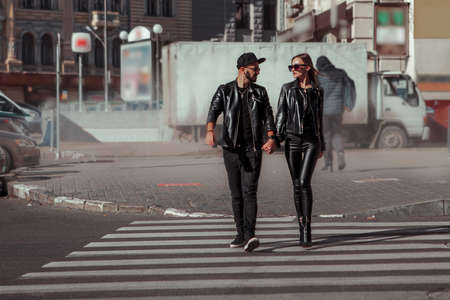 beautiful couple walks across the road in the streetの写真素材