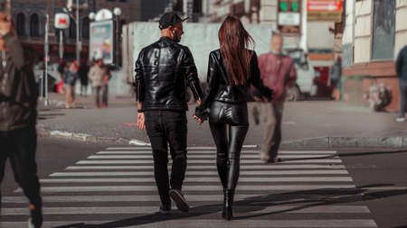 beautiful couple walks across the road in the streetの写真素材