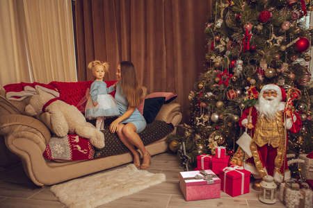 Happy young mother with little baby girl celebrate Christmas and New yearの写真素材