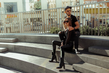 Fashionable young couple hugs in the streetの写真素材