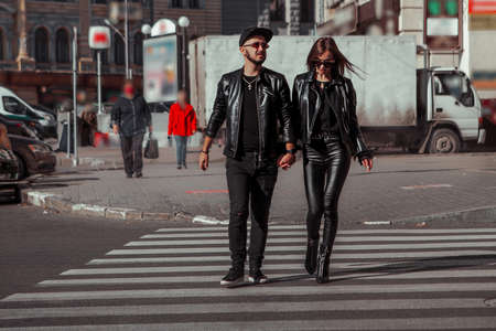 Beautiful woman in leather suit and sunglasses posing in the streetの写真素材