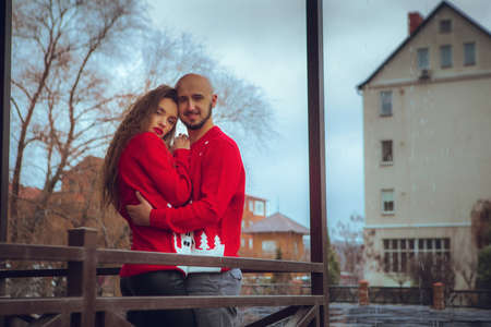 horizontal portrait of beautiful couple hugs on a balcony winter time. Christmas moodの写真素材
