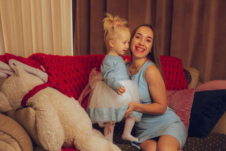 portrait of cute mother and daughter at the christmas treeの写真素材