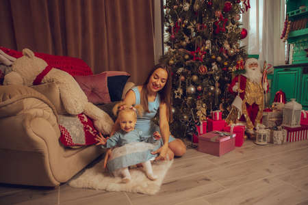portrait of cute mother and daughter at the christmas treeの写真素材