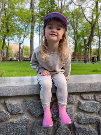 Cutie little girl posing in the park and smiles awayの写真素材