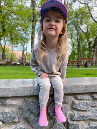 Cutie little girl posing in the park and smiles awayの写真素材