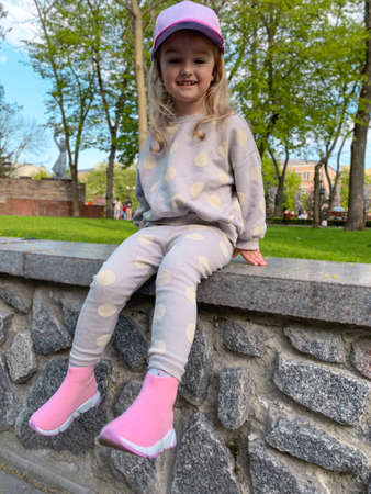 Cutie little girl posing in the park and smiles awayの写真素材