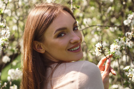 portrait of beautiful girl posing in cherry blossom gardenの写真素材