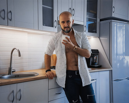 handsome man drinks morning coffee and smiling on cameraの写真素材