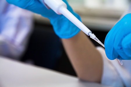 Pipette with drop of liquid in a science research labの写真素材