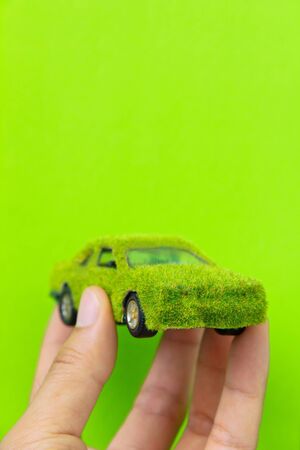 Hand Holding Eco car icon isolate on green backgroundの写真素材