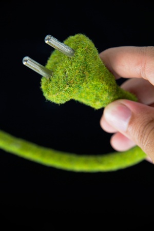 hand holding green electric plug