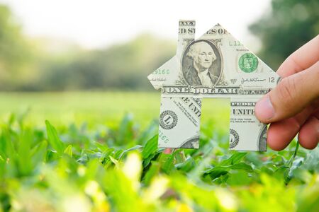 Hand holding banknote house icon,real estate concept の写真素材