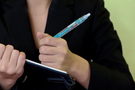 Businesswoman writing in notebook の写真素材