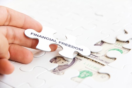 hand holding a puzzle piece, financial freedom concept の写真素材