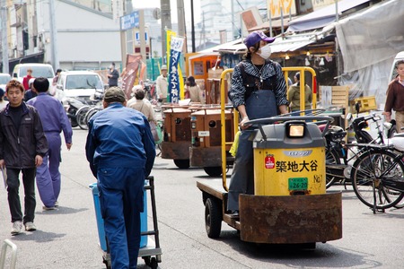 TOKYO, JAPAN- APRIL 15, 2014  Man transporting fishes at Tsukiji Market, Tsukiji market is a large market for fish, fruits and vegetables in central Tokyo, Japan  April 15 2014のeditorial素材