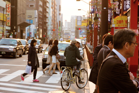 Street life in Shinjuku,Shinjuku district, with crowds of people crossing a crosswalk and sunrise in Tokyo, Japan のeditorial素材