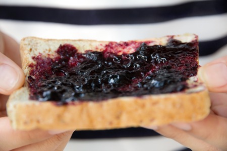 hand holding grape jelly sandwichの写真素材