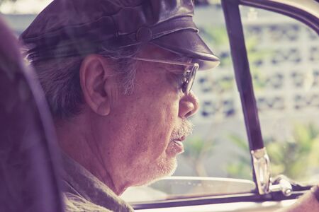 Older man with glasses driving a carの写真素材