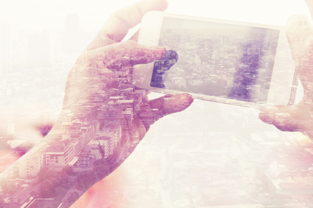 Double exposure image of people with smart phone and cityscape backgroundの写真素材