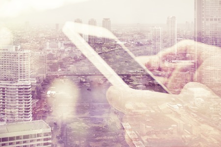 Double exposure image of people with smart phone and cityscape background,Business technology concept.の写真素材