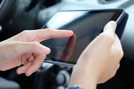 Woman Sitting in the Car and Using digital tablet.Business technology concept.