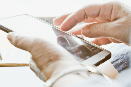 Close up image of older woman checking her phone backgroundの写真素材