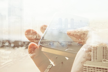 Double exposure of cityscape and smart phone, business technology concept.の写真素材