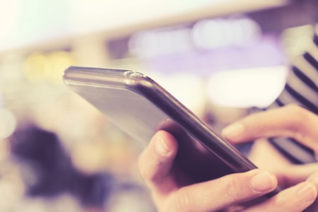 Close up of using smartphone at the airport.