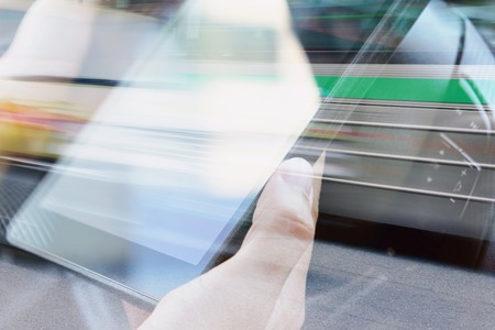 Business man Using digital tablet double exposure and blurred view of car on city streetの写真素材