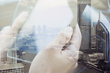 concept image of Business  technology, Using digital tablet double exposure and and cityscape background.の写真素材