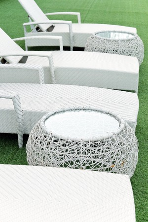 white lounge sunbeds standing on green grass