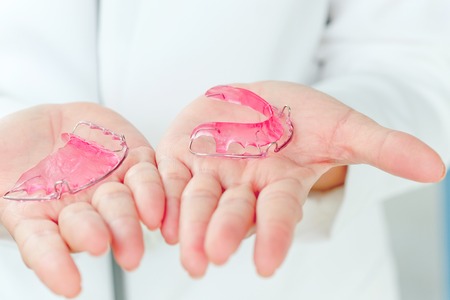 Dentist holding Retainer, Orthodontics Dental concept background