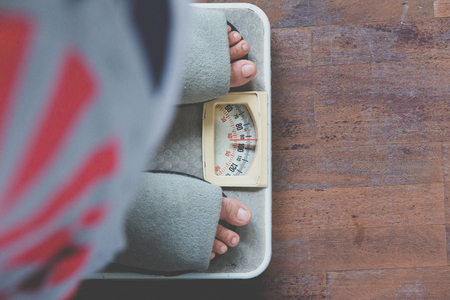 image of woman standing on weighing scaleの写真素材